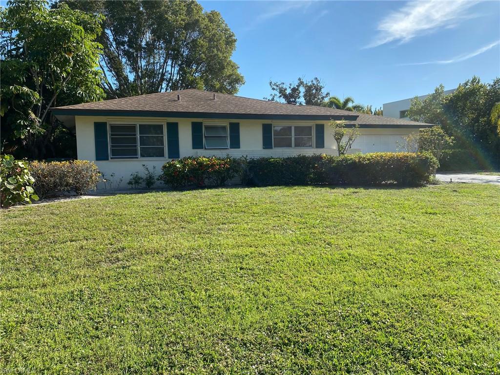 620 Orchid Drive Naples, FL 34102 - Photo 2 of 16 a front view of a house with a yard and garage