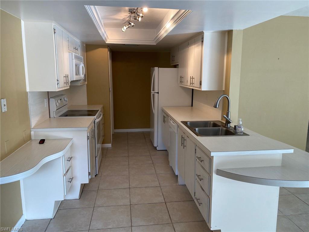 620 Orchid Drive Naples, FL 34102 - Photo 10 of 16 a kitchen with stainless steel appliances a sink stove and cabinets
