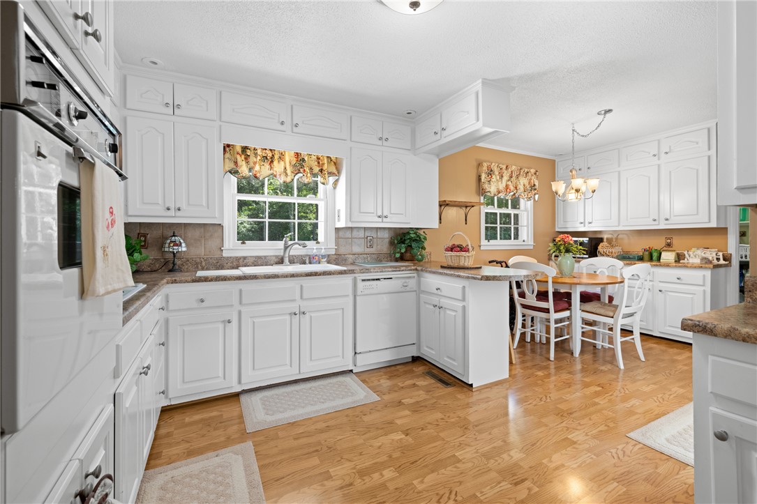 706 Pinewood Drive Pendleton, SC 29670 - Photo 6 of 35 A well-appointed kitchen features white cabinetry and light wood floors, creating a cheerful atmosphere.