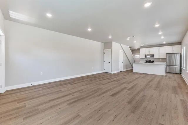 a view of empty room with wooden floor