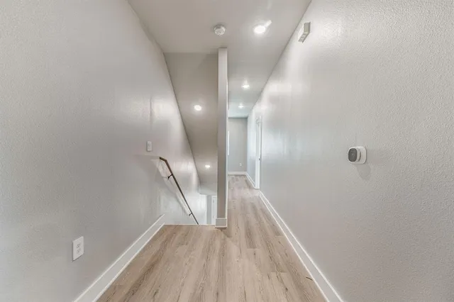 a view of a hallway with wooden floor