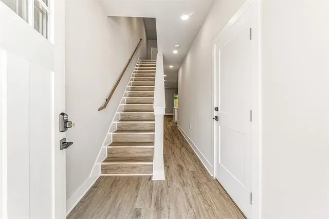a view of a hallway with wooden floor and entryway