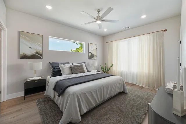 a spacious bedroom with a bed and a chandelier