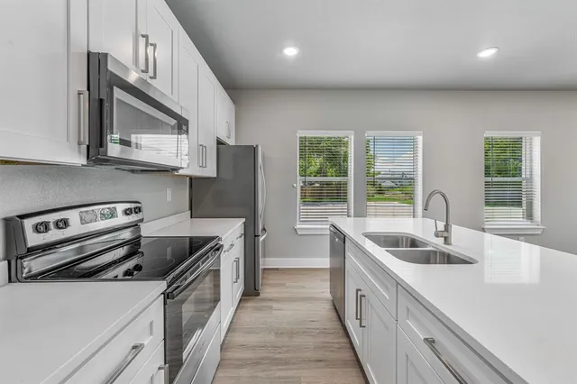 a kitchen with stainless steel appliances granite countertop a sink and a stove