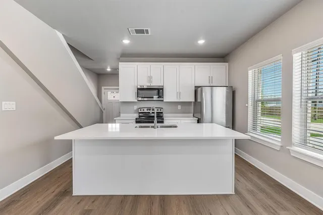 a view of kitchen with stainless steel appliances sink refrigerator and window