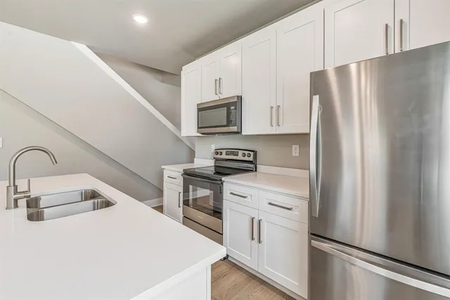 a kitchen with stainless steel appliances a refrigerator sink and cabinets