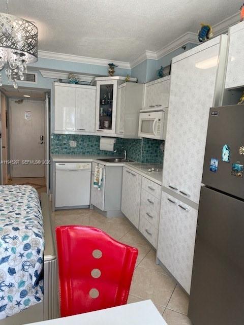 6345 Collins Avenue, Unit 435 Miami Beach, FL 33141 - Photo 22 of 28 a kitchen with granite countertop a sink a stove top oven a refrigerator and cabinets