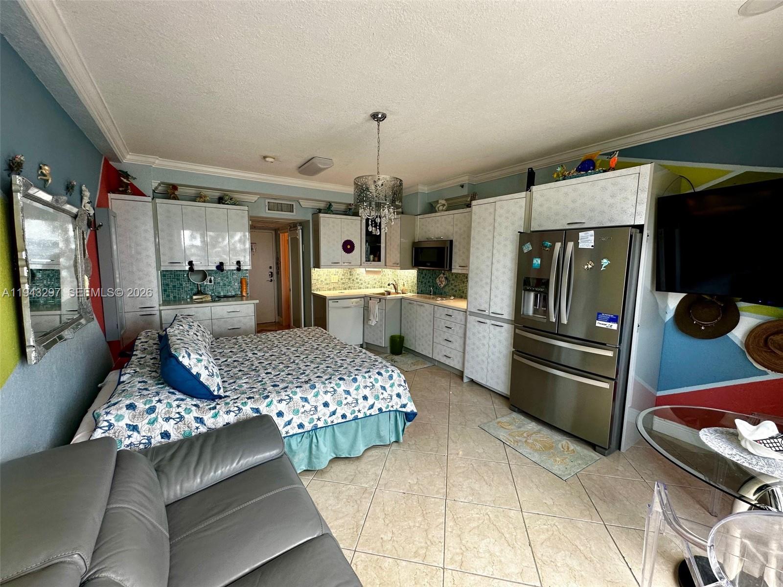 6345 Collins Avenue, Unit 435 Miami Beach, FL 33141 - Photo 5 of 28 a kitchen with refrigerator and cabinets