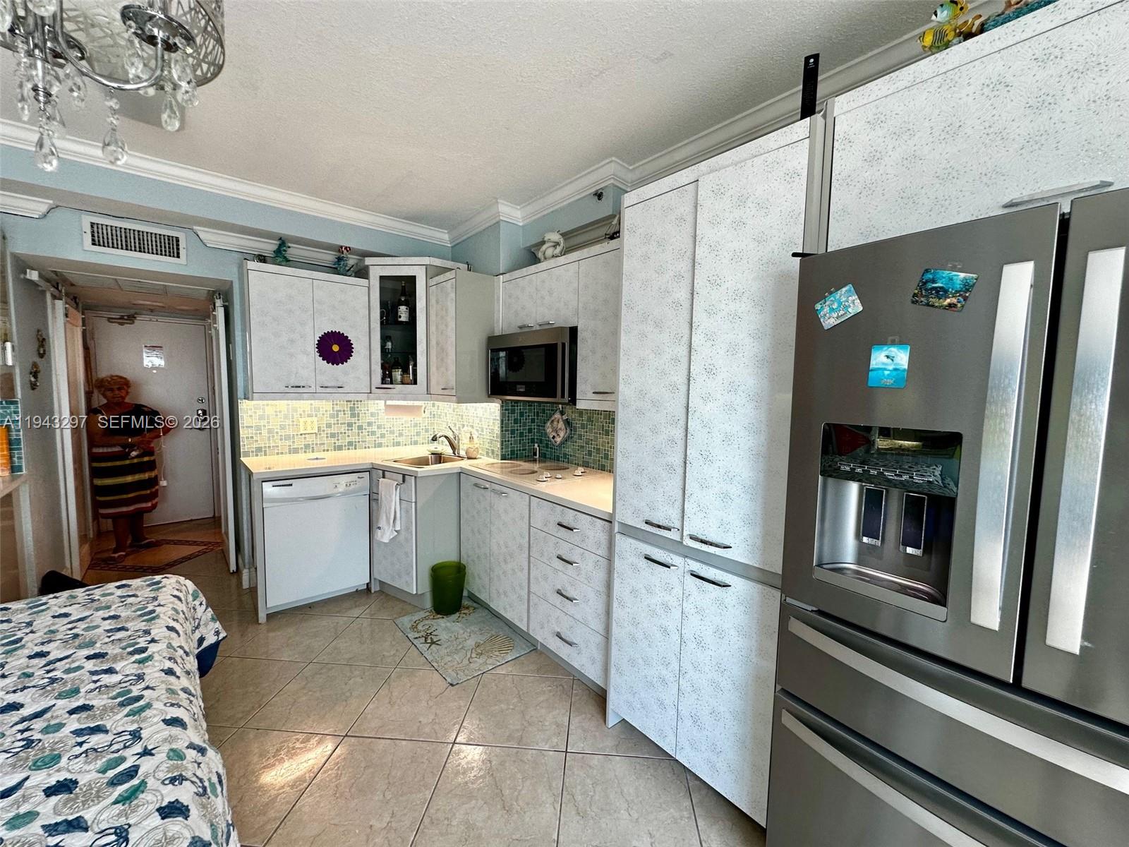 6345 Collins Avenue, Unit 435 Miami Beach, FL 33141 - Photo 8 of 28 a kitchen with a sink refrigerator and cabinets