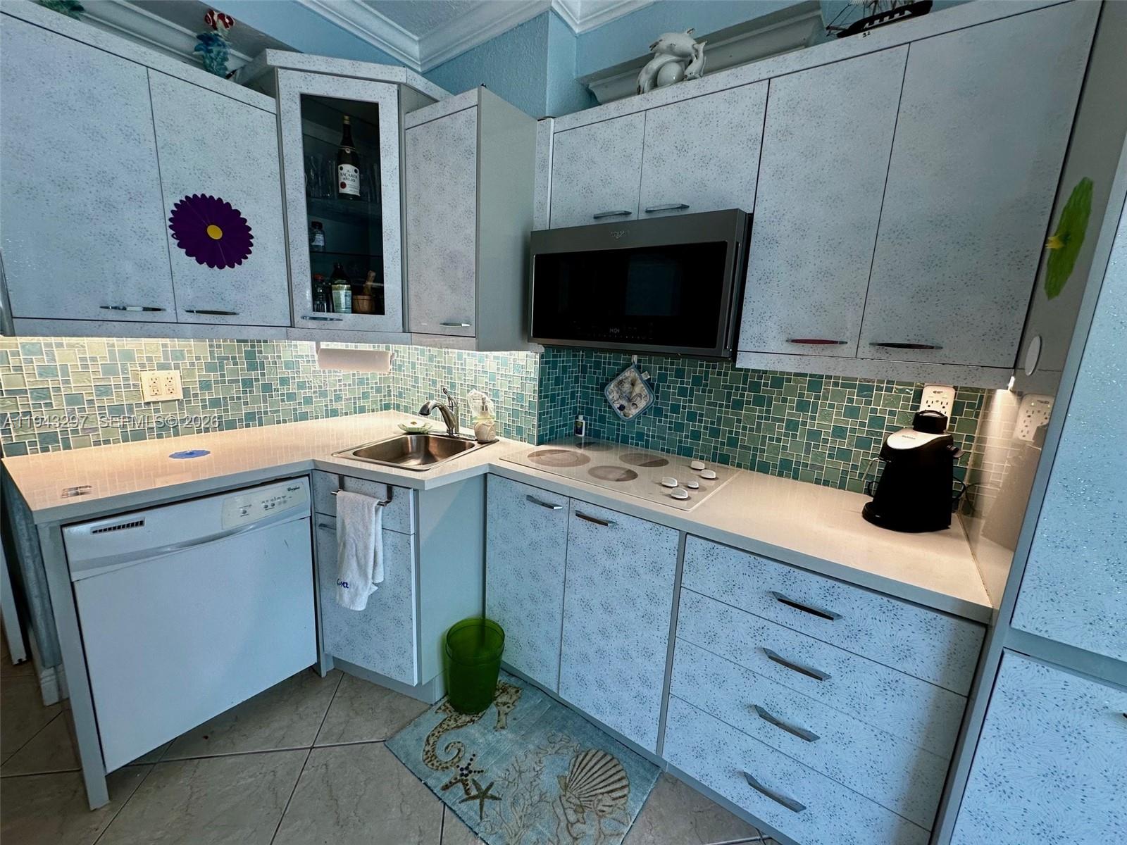 6345 Collins Avenue, Unit 435 Miami Beach, FL 33141 - Photo 9 of 28 a kitchen with a sink a stove and cabinets