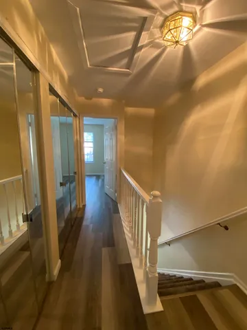 a view of a livingroom with a hall and wooden floor