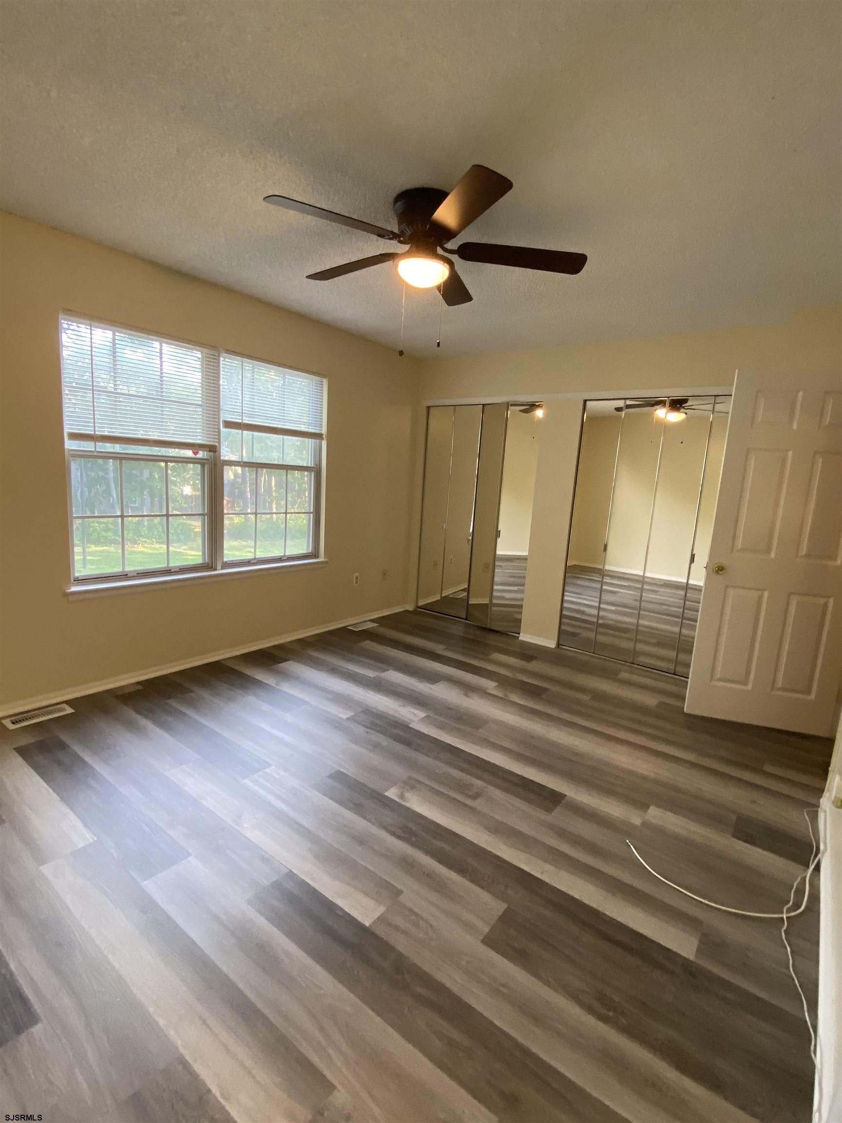 66 Shawnee Place, Unit 66 Galloway Township, NJ 08205 - Photo 17 of 20 a view of an empty room with wooden floor and a window