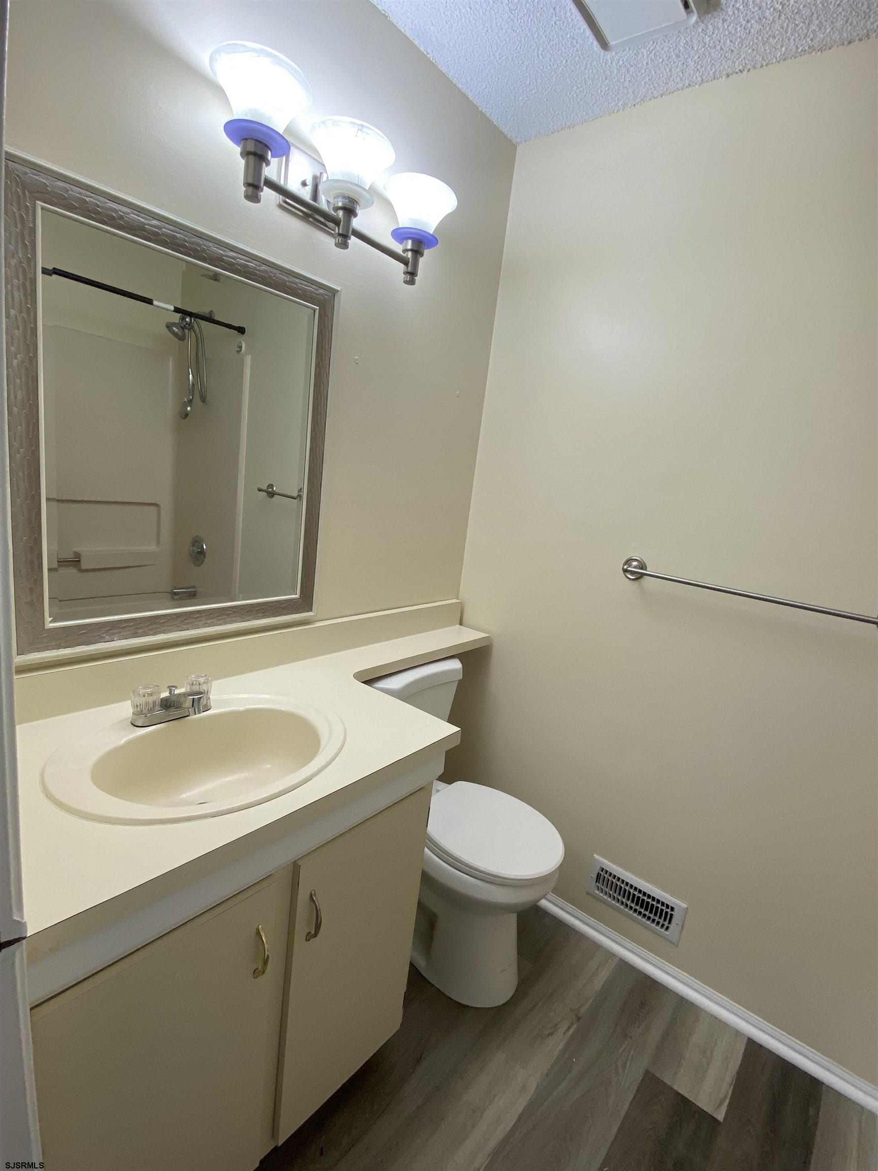 66 Shawnee Place, Unit 66 Galloway Township, NJ 08205 - Photo 18 of 20 a bathroom with a granite countertop sink toilet and a mirror