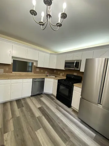 a kitchen with a refrigerator sink and cabinets