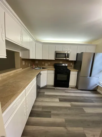 a large kitchen with a stove and a refrigerator