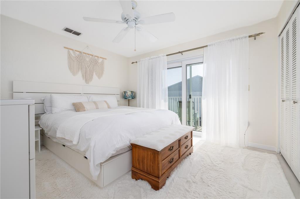 4786 South Atlantic Avenue, Unit B1 Ponce Inlet, FL 32127 - Photo 12 of 22 a spacious bedroom with a bed a window and a walk in closet