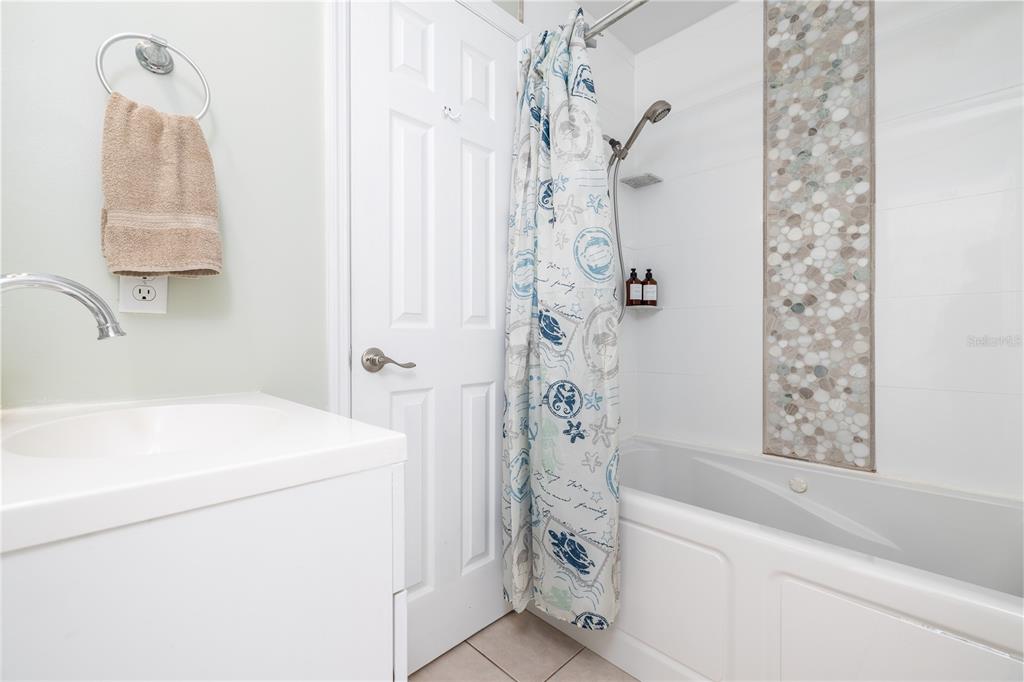 4786 South Atlantic Avenue, Unit B1 Ponce Inlet, FL 32127 - Photo 16 of 22 a bathroom with a sink a mirror and a shower