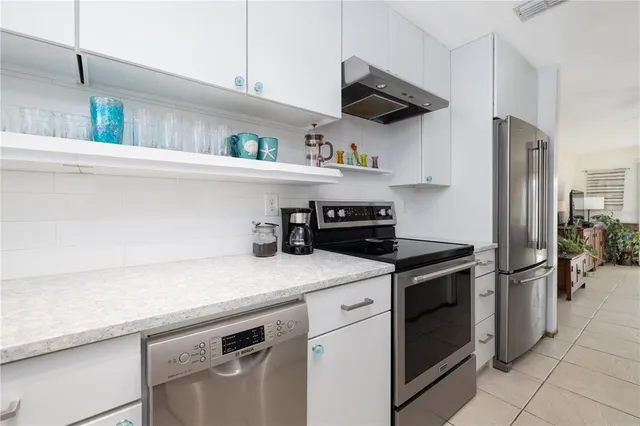 a kitchen with stainless steel appliances granite countertop a sink and cabinets with wooden floor