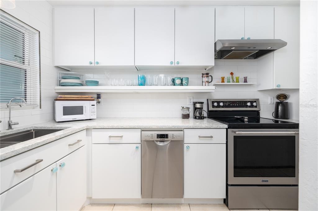 4786 South Atlantic Avenue, Unit B1 Ponce Inlet, FL 32127 - Photo 8 of 22 a kitchen with stainless steel appliances granite countertop a sink and cabinets with wooden floor