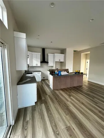 a large white kitchen with wooden floor
