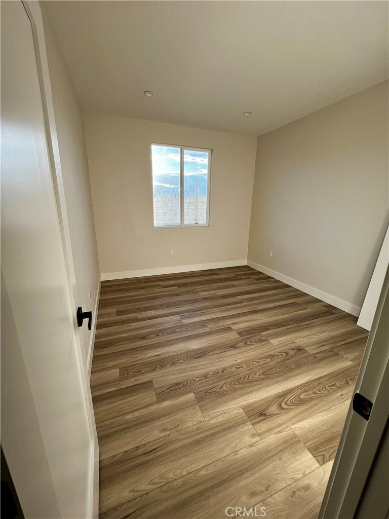 66231 3rd Street Desert Hot Springs, CA 92240 - Photo 5 of 13 a view of an empty room with wooden floor and a window
