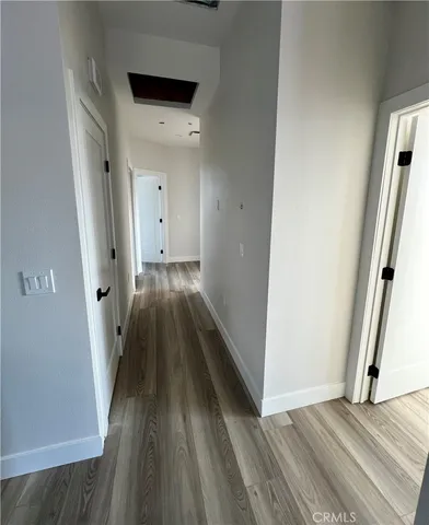 a view of a hallway with wooden floor and staircase