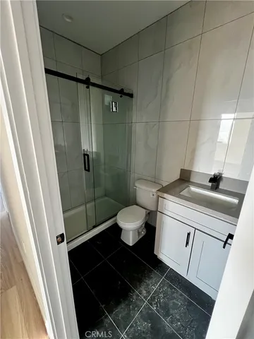 a bathroom with a granite countertop sink toilet and shower