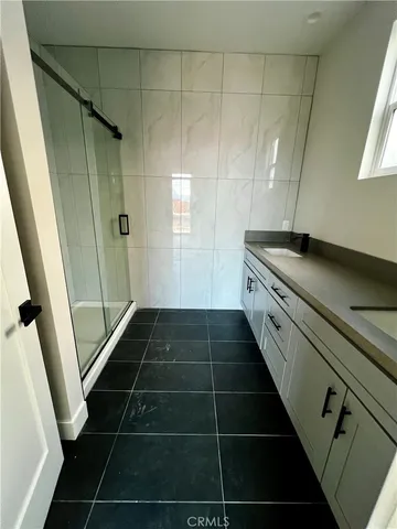 a bathroom with a granite countertop shower and a sink