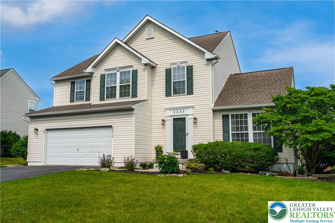 A classic two-story residence with a charming facade and a manicured front lawn.