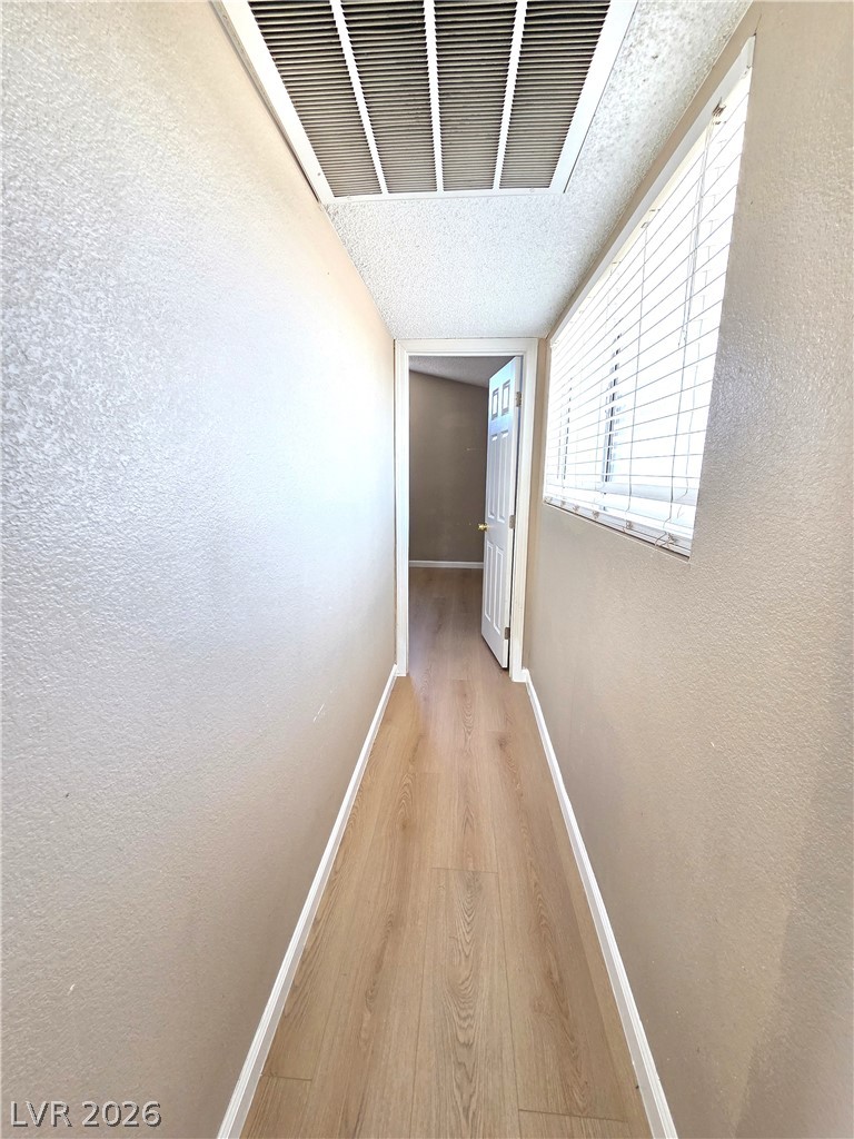 2882 Sandyfalls Way Las Vegas, NV 89142 - Photo 7 of 18 A well-maintained hallway with durable wood flooring and ample natural light.