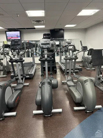 a gym room with gym equipment and a large window
