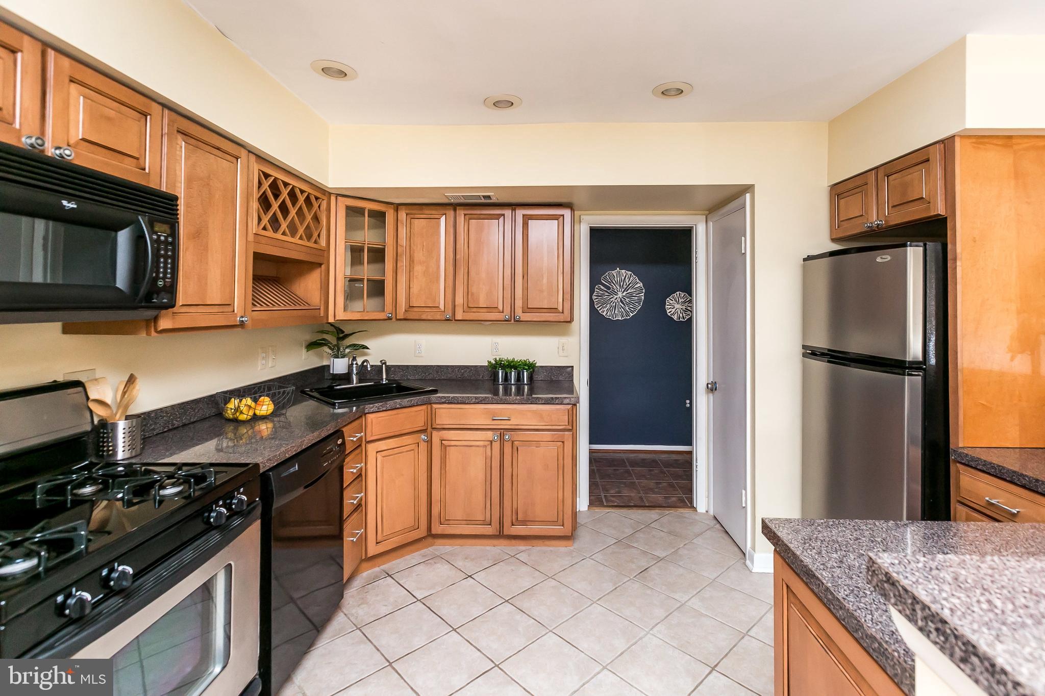 114 Cross Keys Road, Unit R114E Baltimore, MD 21210 - Photo 13 of 33 a kitchen with stainless steel appliances granite countertop a refrigerator stove and sink