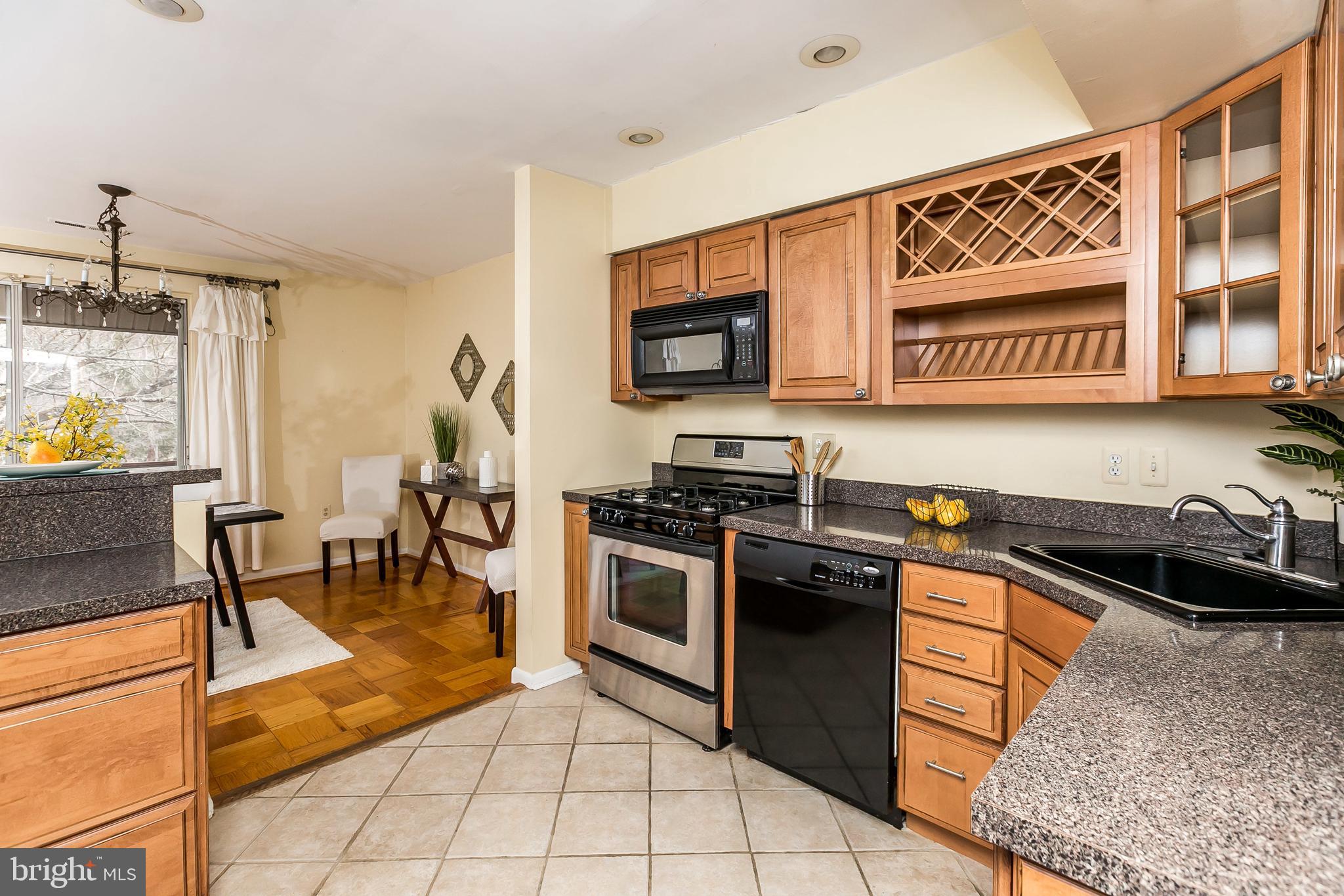 114 Cross Keys Road, Unit R114E Baltimore, MD 21210 - Photo 15 of 33 a kitchen with stainless steel appliances granite countertop a stove a sink and a microwave