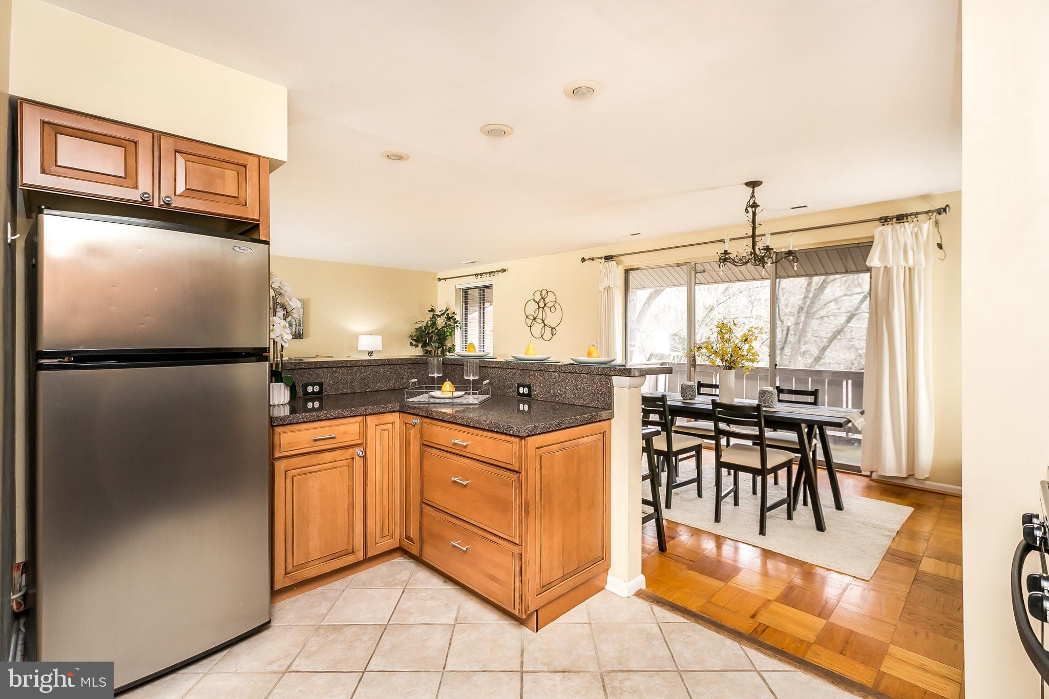 114 Cross Keys Road, Unit R114E Baltimore, MD 21210 - Photo 16 of 33 a kitchen with stainless steel appliances granite countertop a refrigerator and a stove top oven