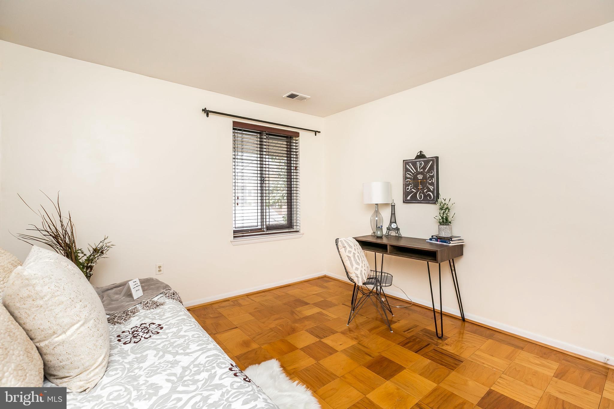 114 Cross Keys Road, Unit R114E Baltimore, MD 21210 - Photo 18 of 33 a bedroom with a bed and a table in it