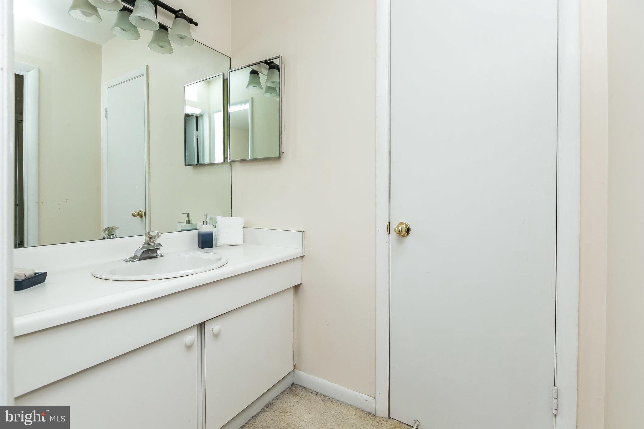 114 Cross Keys Road, Unit R114E Baltimore, MD 21210 - Photo 25 of 33 a bathroom with a sink and a mirror
