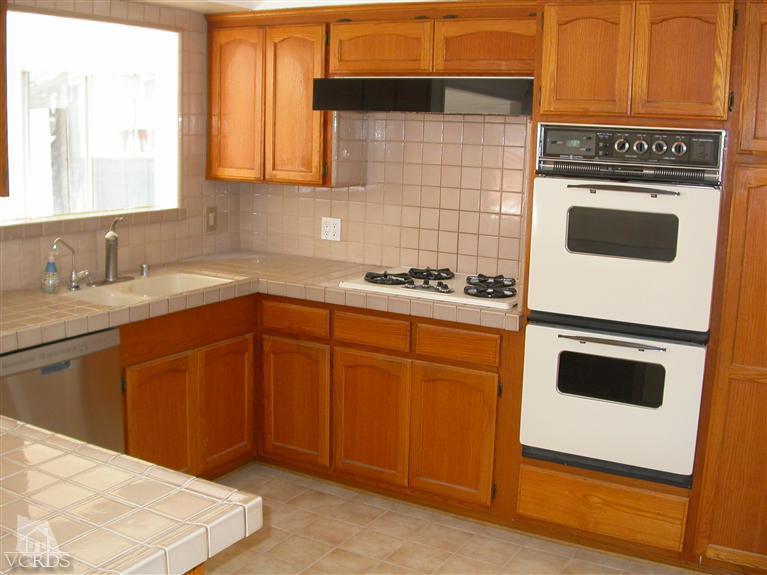 7248 Arthur Rondo Ventura, CA 93003 - Photo 7 of 28 a kitchen with stainless steel appliances granite countertop wooden cabinets a stove a sink and dishwasher