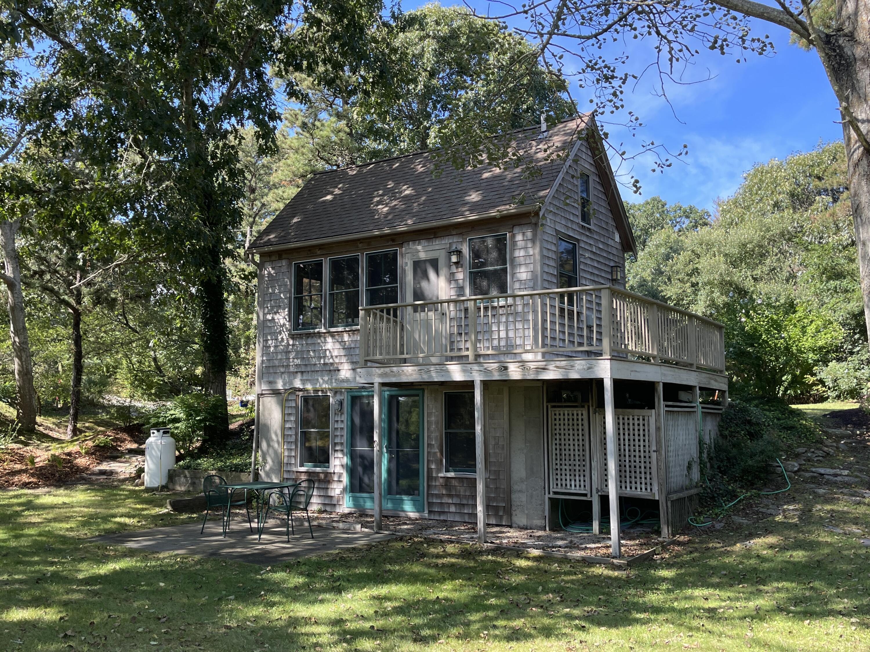 339 Coles Neck Road Wellfleet, MA 02667 - Photo 1 of 30 a front view of a house with a garden