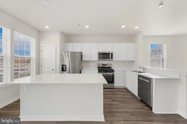 a kitchen with stainless steel appliances a refrigerator sink and stove