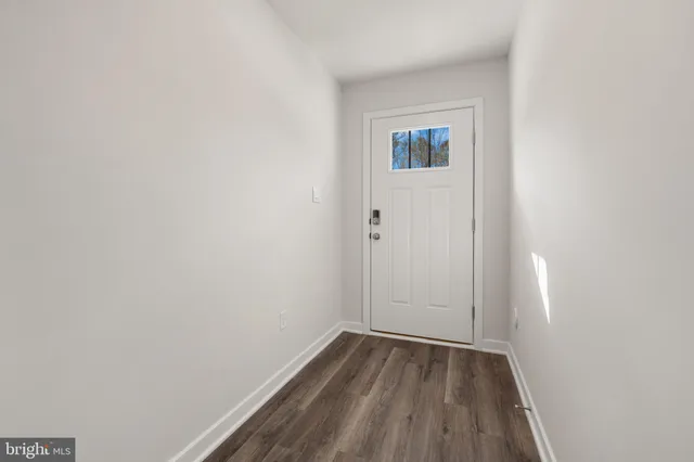 a view of a small space with wooden floor and a window