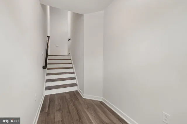 a view of a hallway with wooden floor and entryway