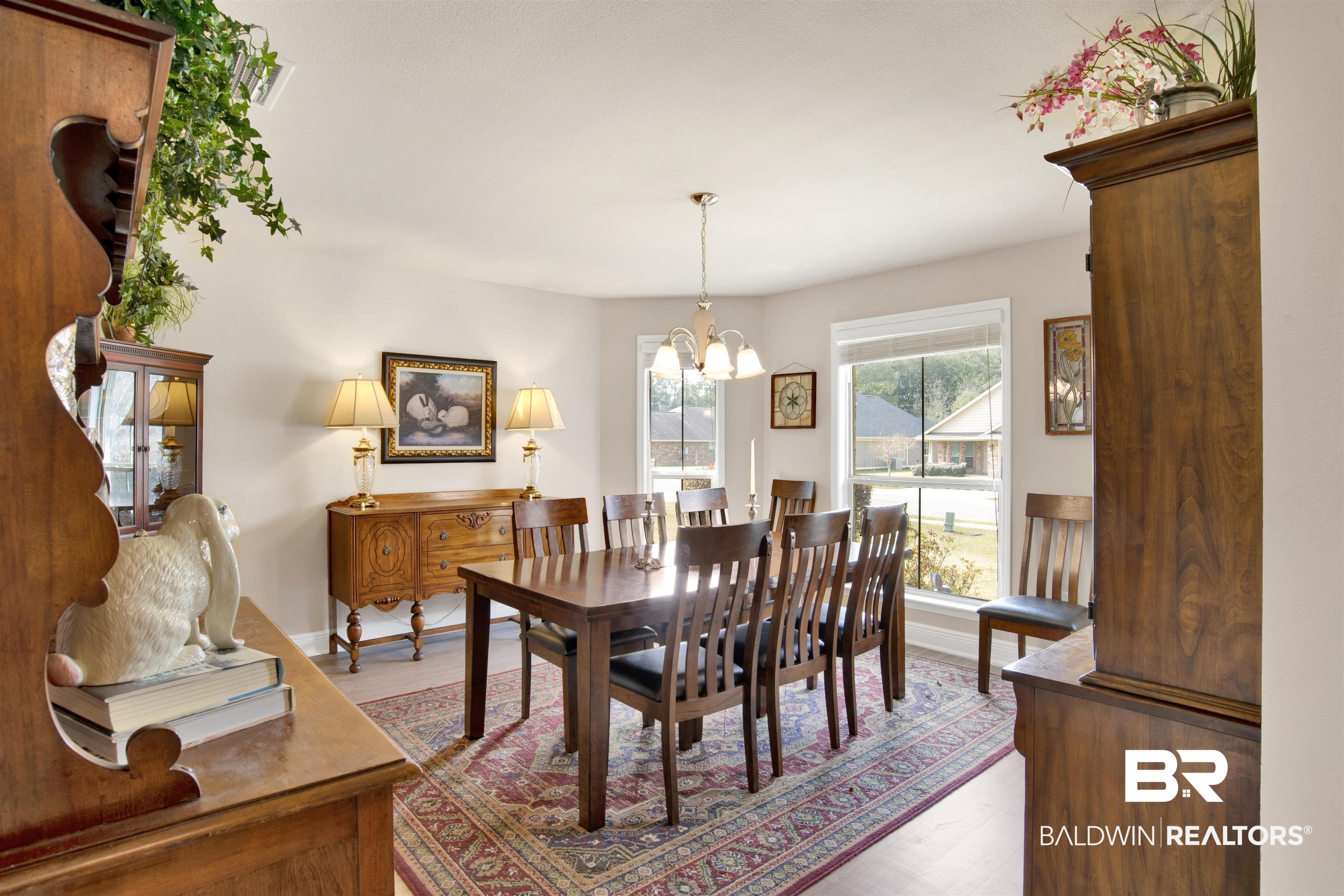 22056 Garland Loop Silverhill, AL 36576 - Photo 3 of 28 Dining space featuring an inviting chandelier, baseboards, and wood finished floors
