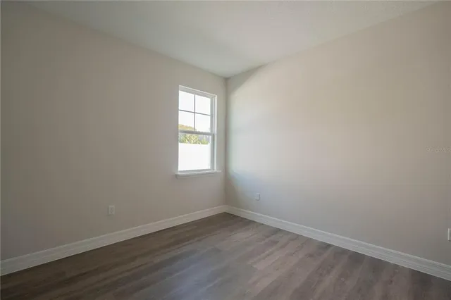 a front view of house with yard and trees in the background