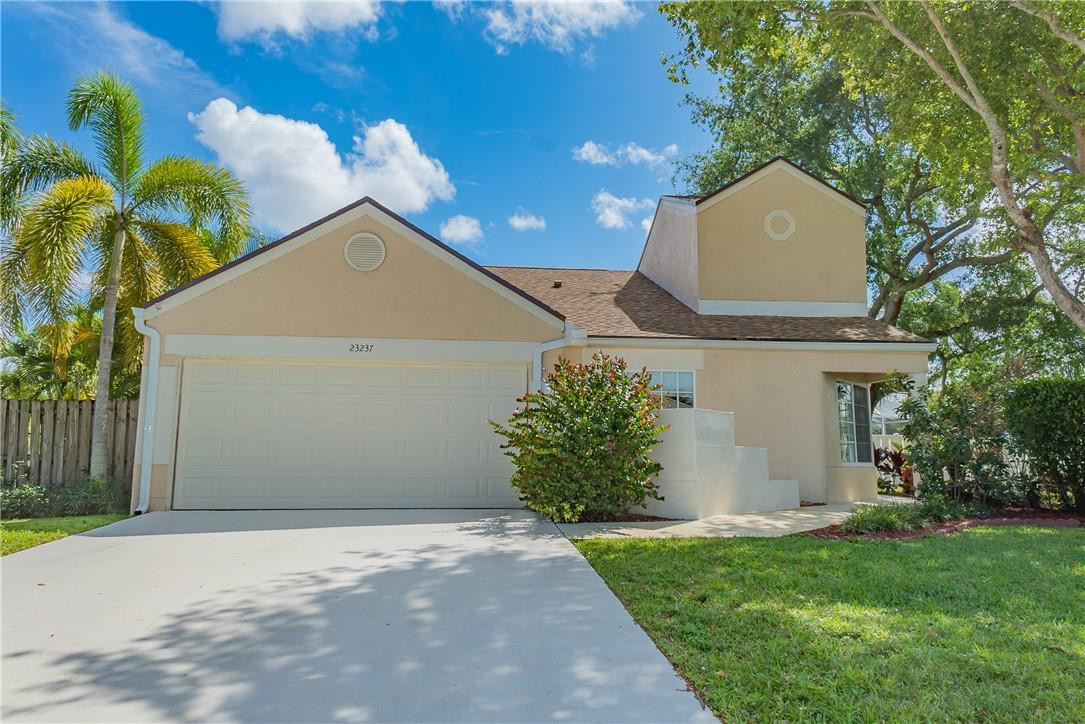 23237 Bentley Place Boca Raton, FL 33433 - Photo 2 of 16 a front view of a house with a garden and plants