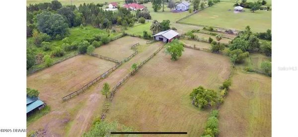an aerial view of a house with a yard and garden