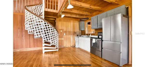 a kitchen with granite countertop stainless steel appliances and wooden floor