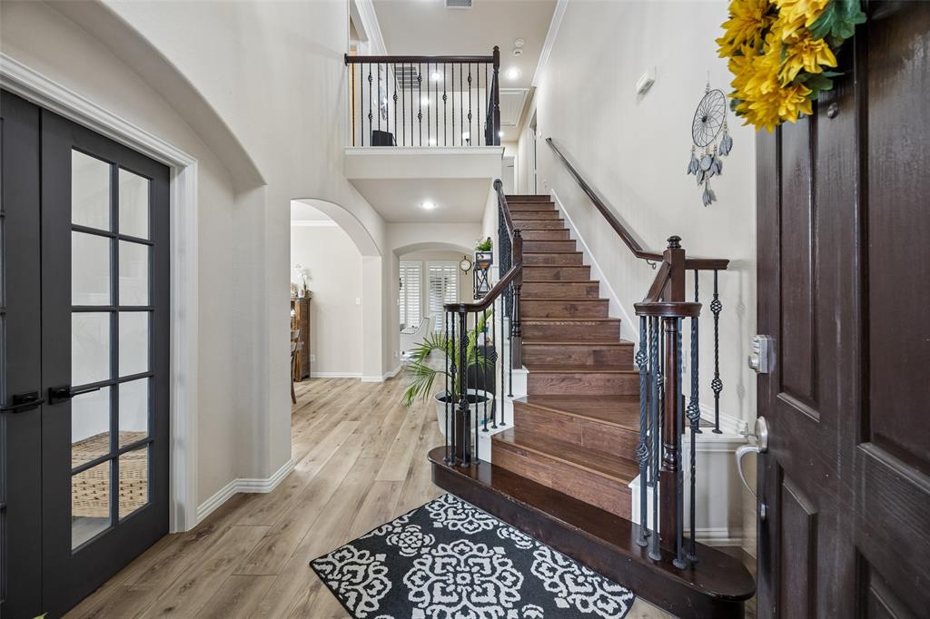 2865 Ridge View Road Frisco, TX 75034 - Photo 3 of 38 Wood-finish flooring throughout the entry, a dark wood staircase with wrought iron balusters, and a second-level landing with matching balusters