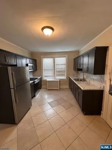 a kitchen with granite countertop a refrigerator and a stove top oven