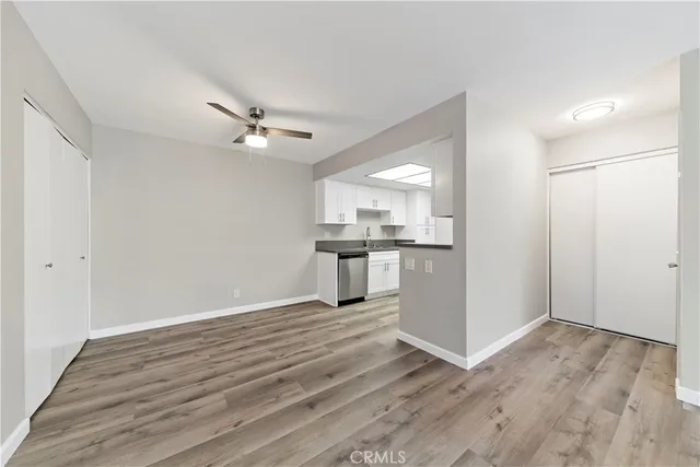 wooden floor in an empty room with a kitchen