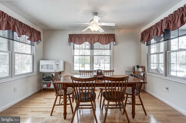 a view of a a dining room with furniture window and wooden floor